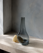 Stoneveil No. 007 one-of-one smoke-blue glass and golden-ochre stone vase displayed empty
