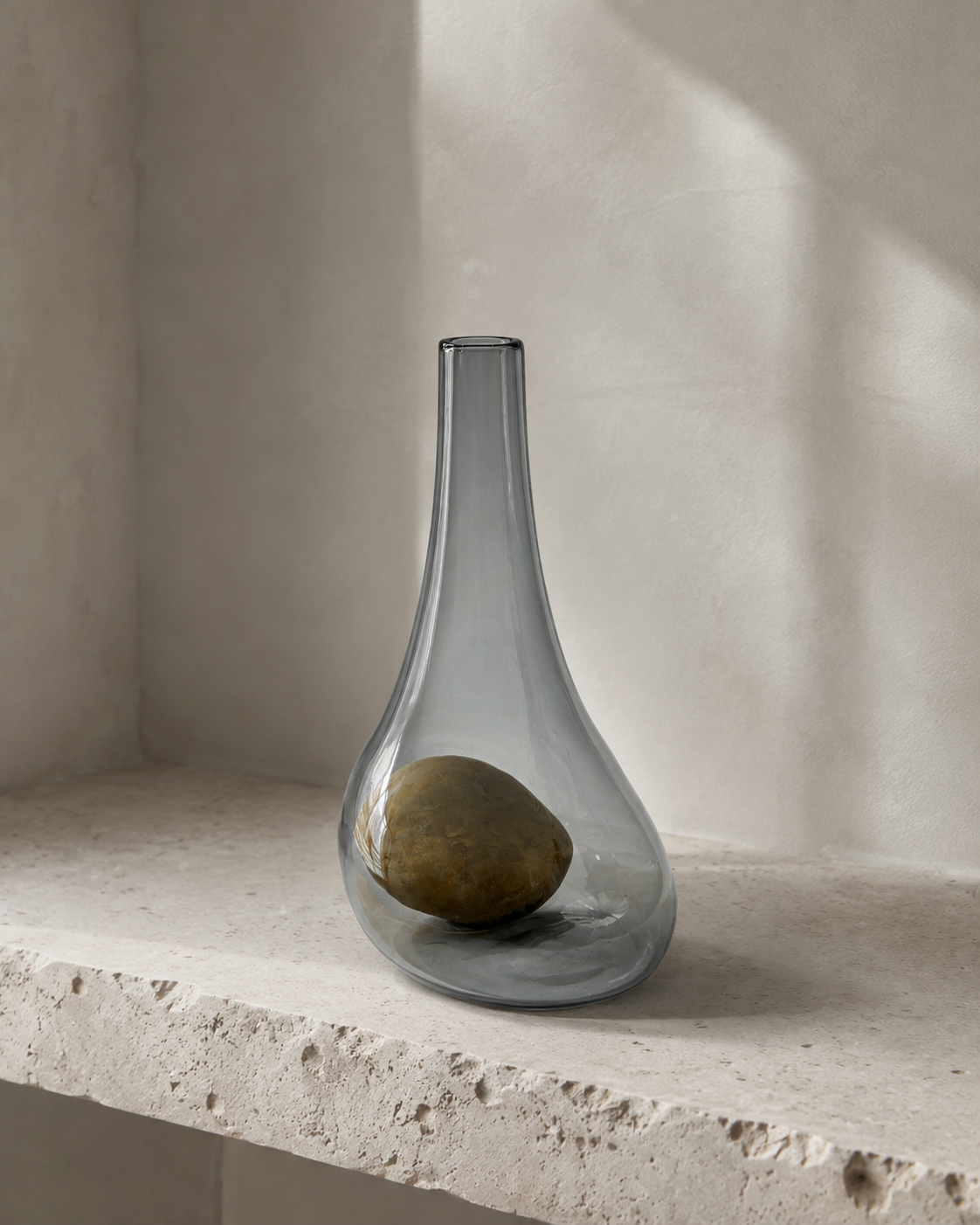 Alternate view of Stoneveil No. 003 gray-blue glass vase paired with a smooth ochre stone