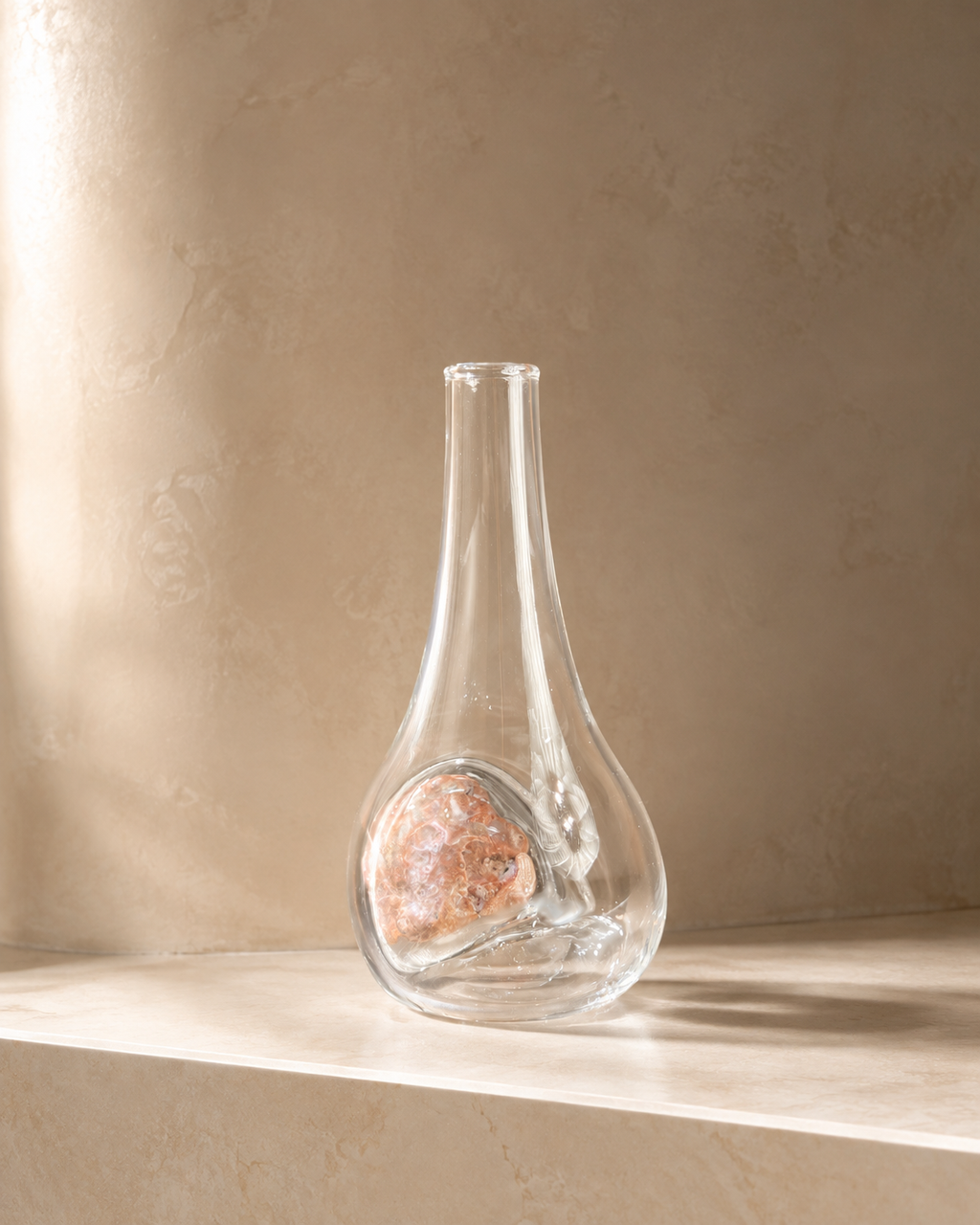 Alternate view of Stoneveil No. 004 clear glass vase paired with a coral-pink natural stone