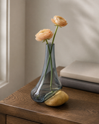 Stoneveil No. 003 small bud vase styled with pale apricot ranunculus on a reading desk
