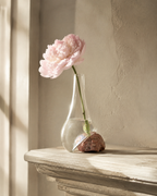 Stoneveil No. 006 small sculptural vase styled with a blush peony on a fireplace ledge