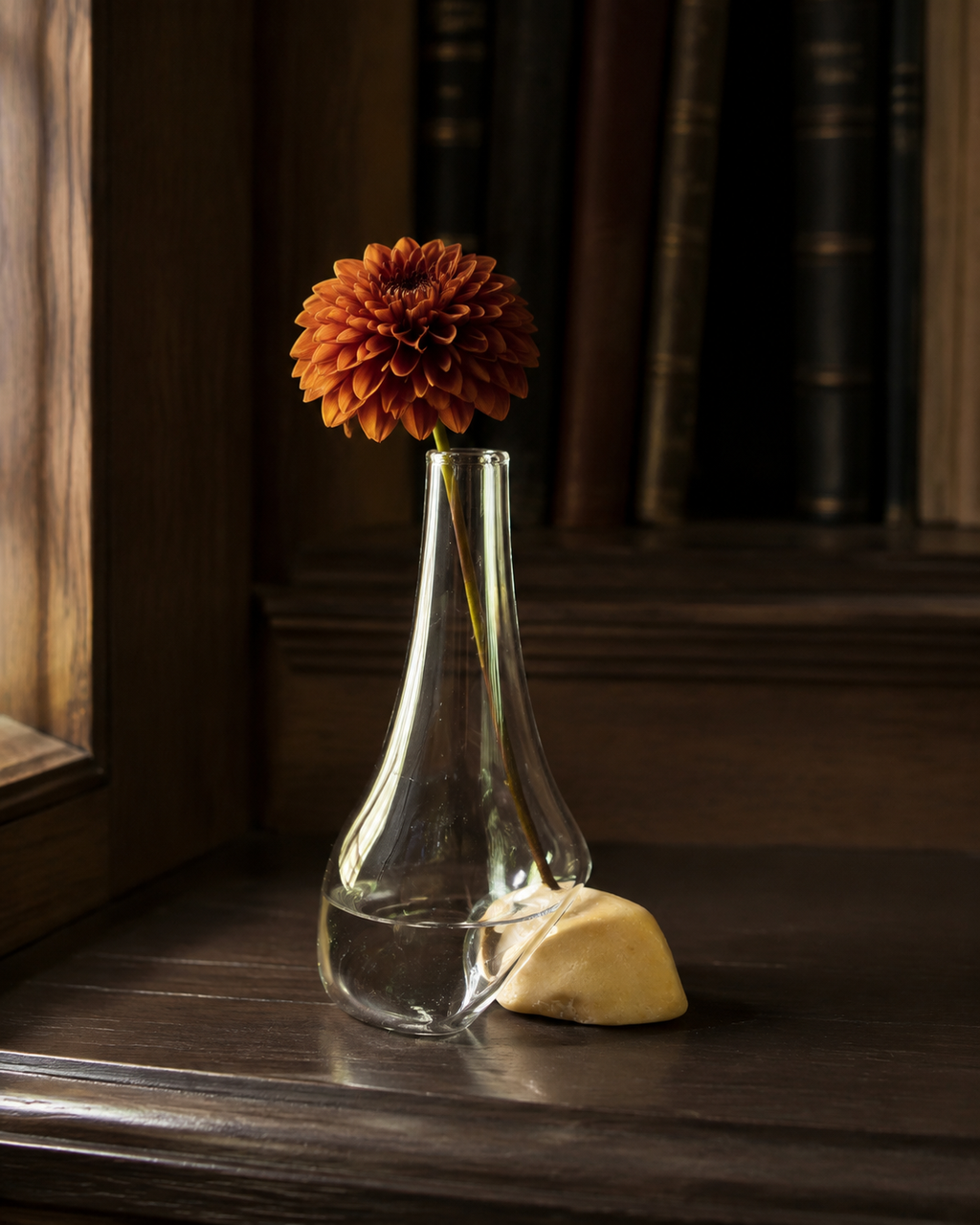 Stoneveil No. 005 small sculptural vase styled with a rust dahlia on an oak library console