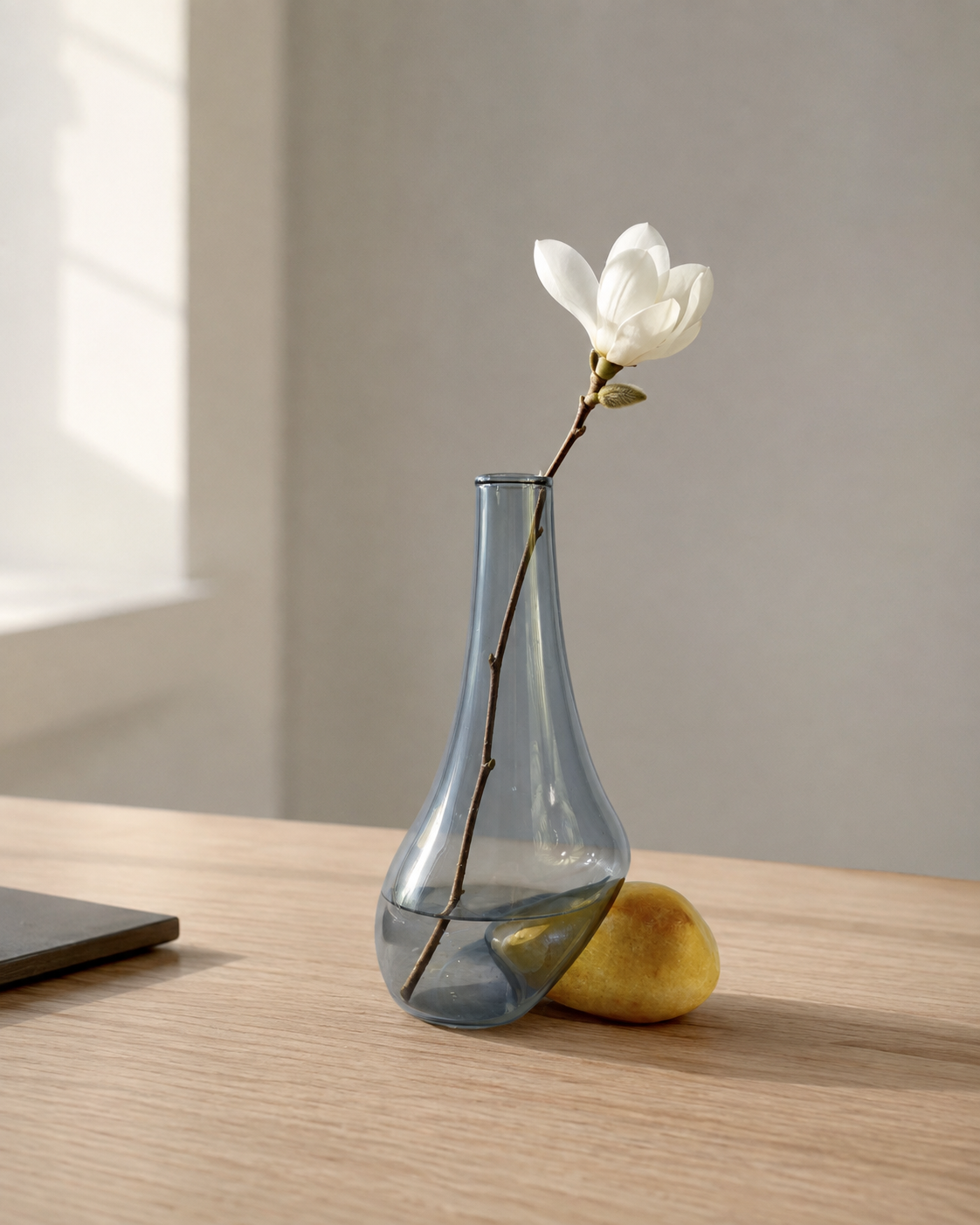 Stoneveil No. 007 small sculptural vase styled with white magnolia on an executive desk