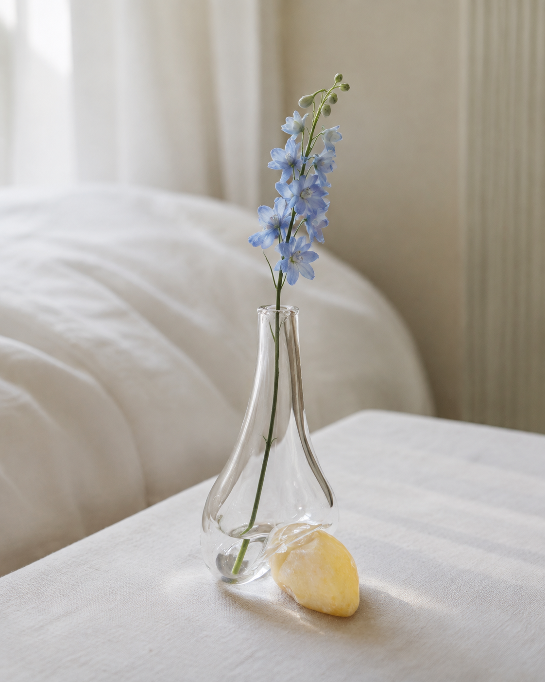 Stoneveil No. 005 clear glass and ivory stone vase with a pale blue delphinium