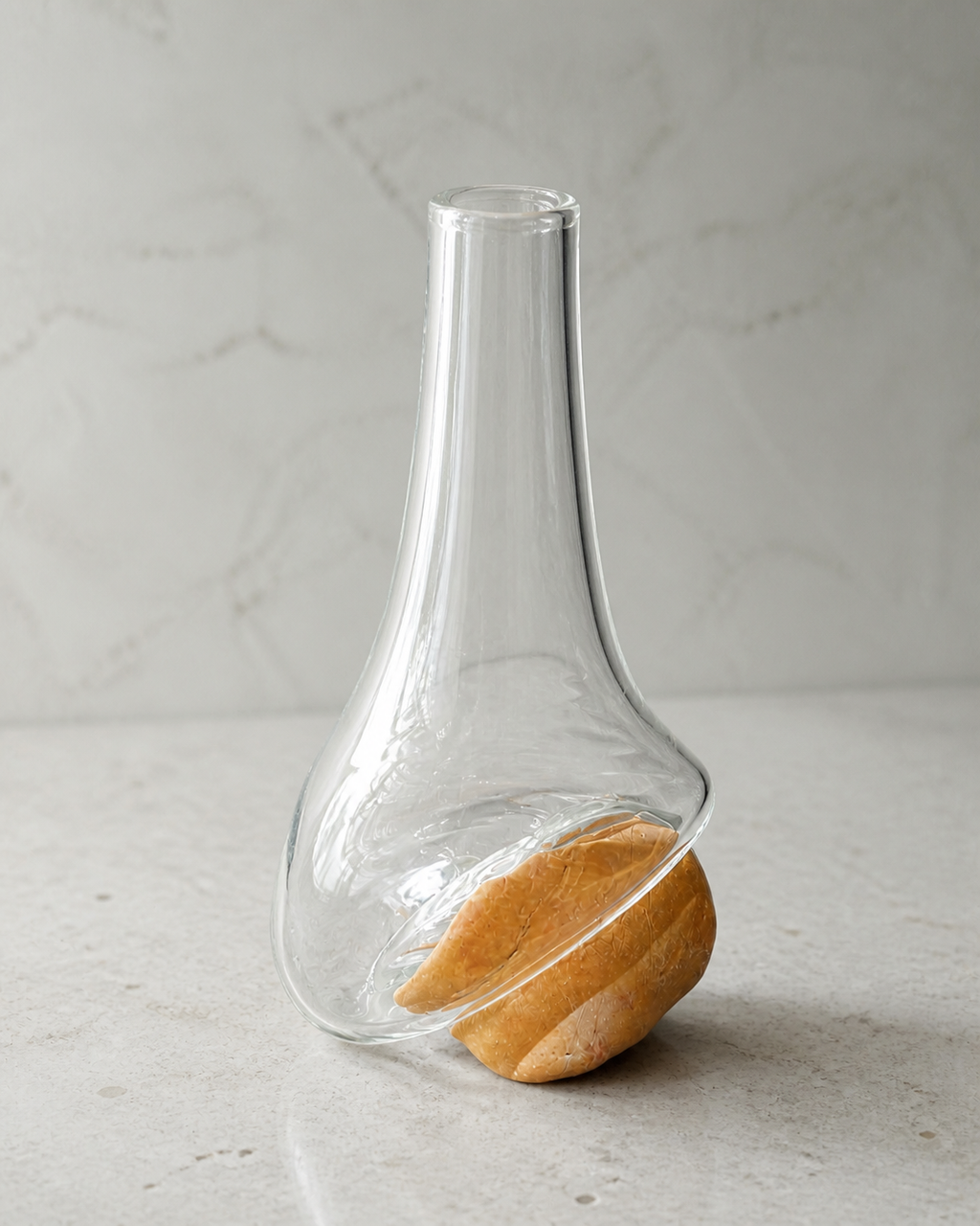 Detail of the diagonal glass fold wrapping around the natural ochre stone