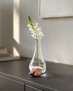 Stoneveil No. 006 clear glass and mauve stone vase with a white snapdragon