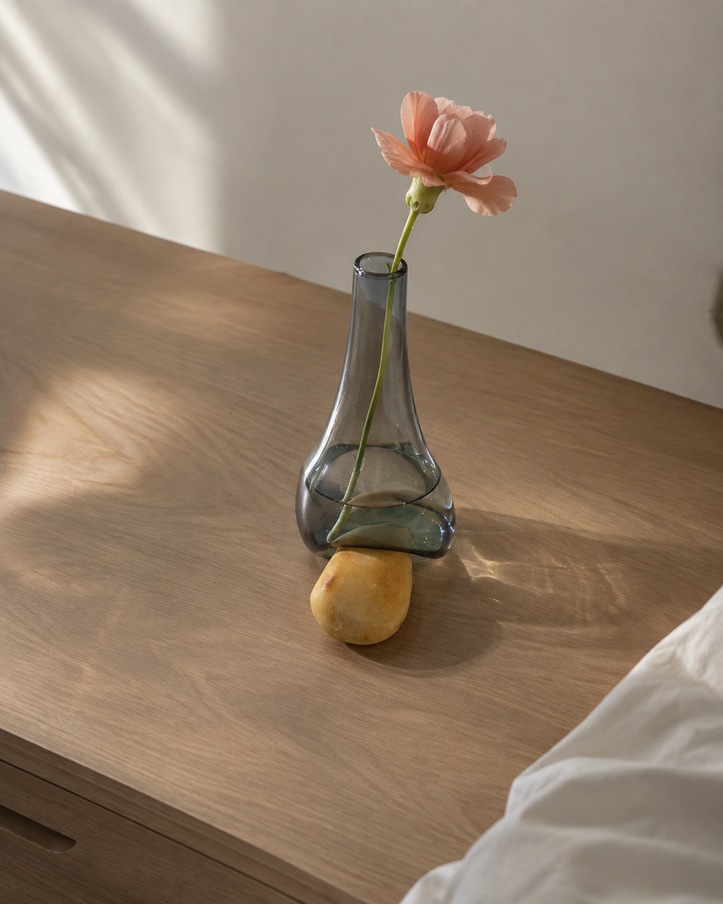 Stoneveil No. 007 one-of-one bud vase styled with peach stock on a walnut bedside table
