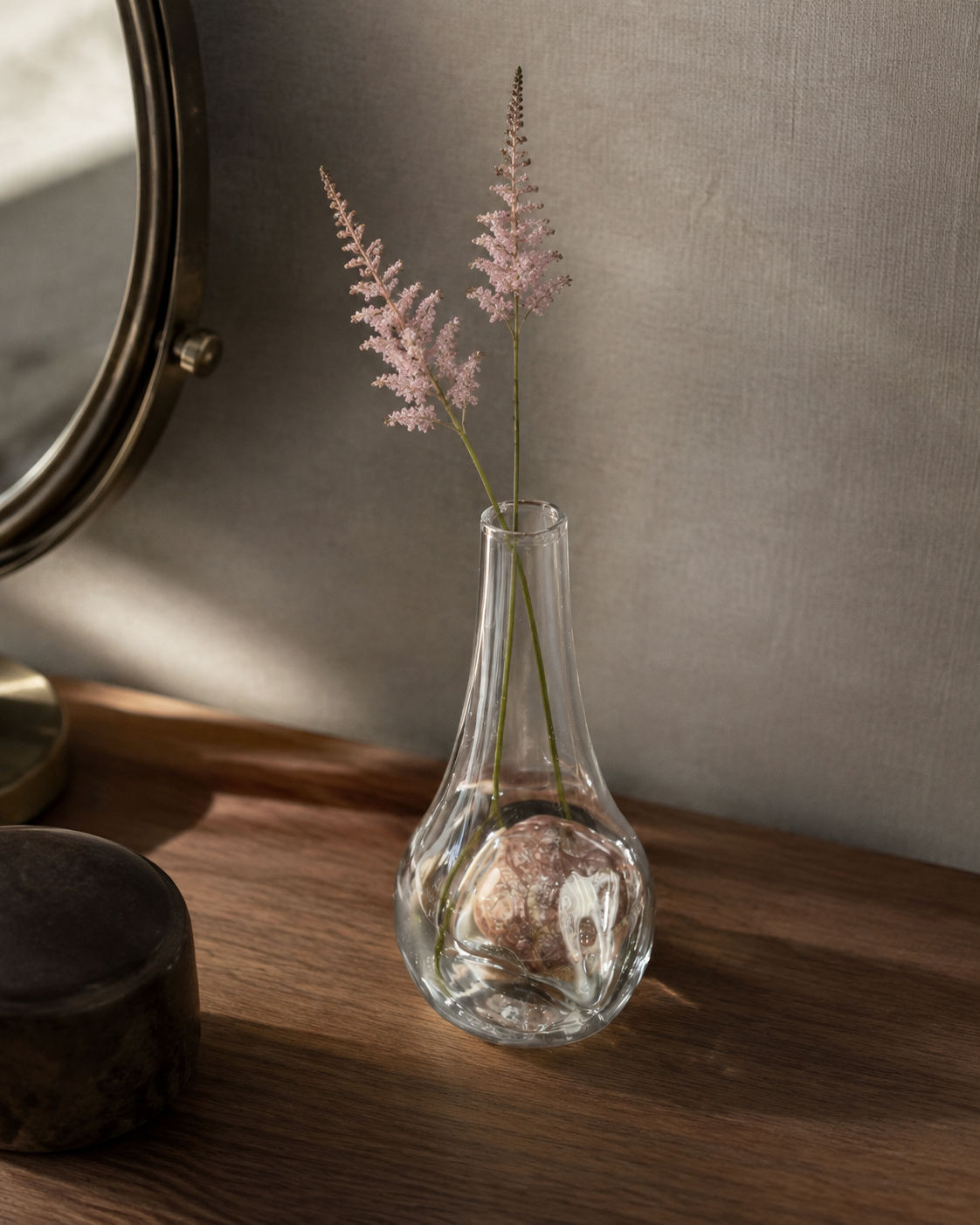 Stoneveil No. 006 clear glass vase styled with pale pink astilbe on a quiet dressing table